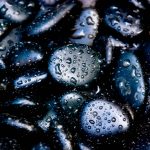 black pebbles covered in raindrops