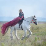 mage-like woman riding a white horse