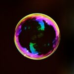 a soap bubble floating on a black background, iridescent and reflective